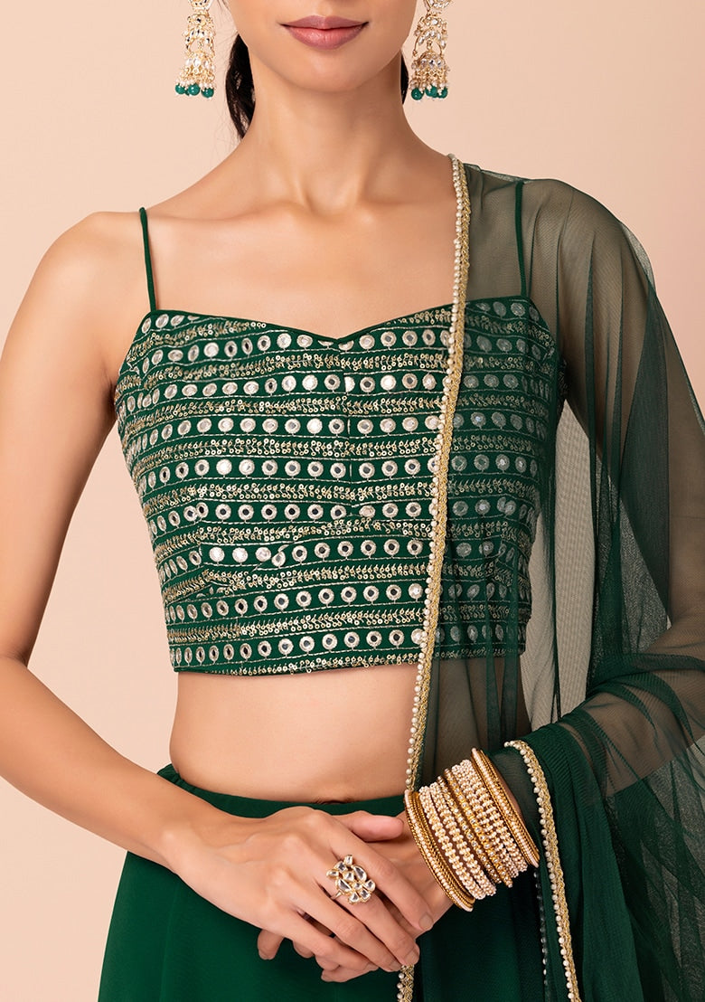Shop green ruffle lehenga with mirror work crop top and net dupatta