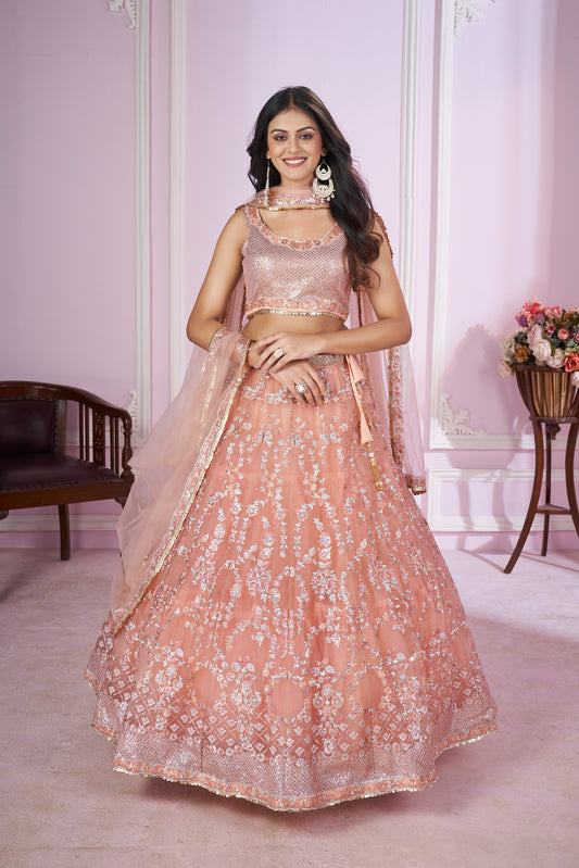 Peach pink embroidered lehenga choli with sequin blouse and net dupatta – perfect pastel outfit for bridesmaids & festive events.

