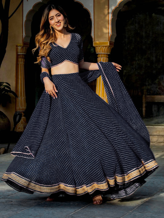 Woman in a black bandhani lehenga choli with golden border, perfect for weddings and festive night events – elegant Indian ethnic look.


